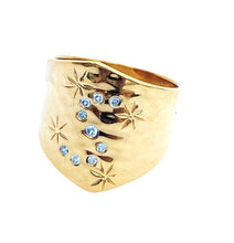 Load image into Gallery viewer, A gold-colored brass ring with blue zirconia stones set in an S-shape pattern, featuring star designs.