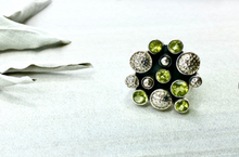 Load image into Gallery viewer, Ring with green gemstones on a white fabric background