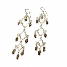 Load image into Gallery viewer, Silver earrings with dark gemstones on a light wooden surface