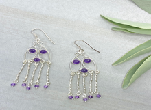 Load image into Gallery viewer, Silver earrings with purple beads on a light gray background