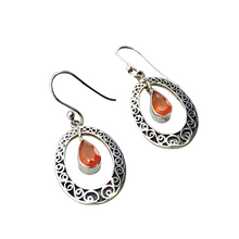 Load image into Gallery viewer, Silver earrings with teardrop-shaped orange stones on a light gray background