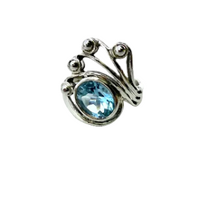 Load image into Gallery viewer, Silver pendant with a blue gemstone on a light fabric background